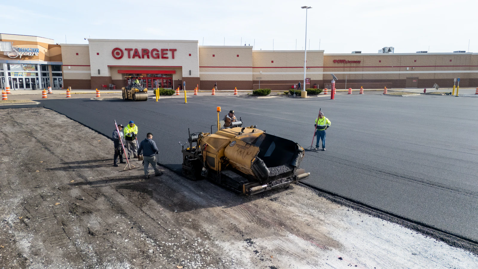 Advantage Paving crew laying new asphalt with a paver in front of a Target store