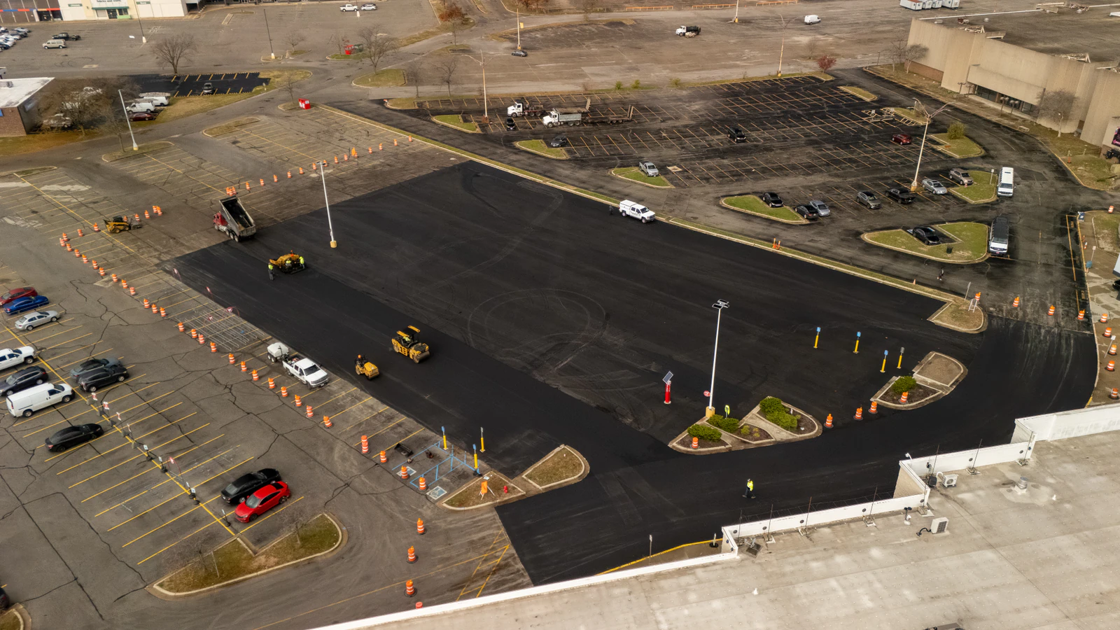 Aerial view of a dump truck feeding asphalt into a paver during the Target parking lot emergency repair