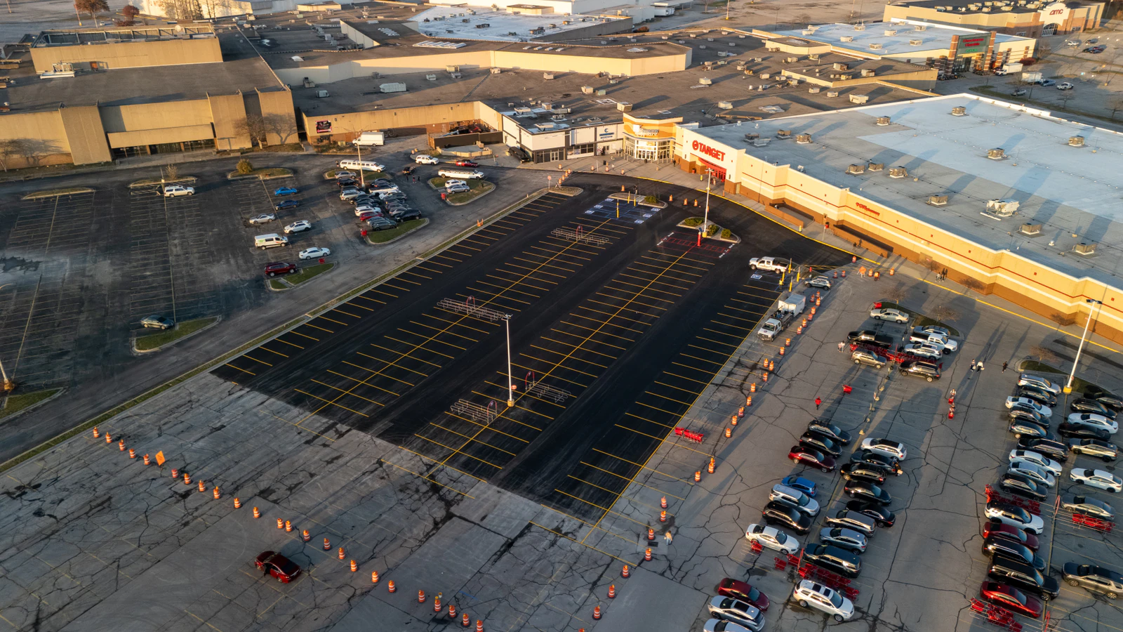Golden-hour aerial view of a Target store parking lot with a freshly paved section completed by Advantage Paving